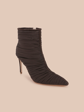 The Fulton Mesh Bootie is a black, high-heeled stiletto bootie featuring a pointed toe and ruched fabric detailing, showcased against a plain beige background.