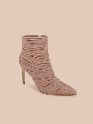 Il modello Fulton Mesh Bootie è uno stivaletto con tacco di colore rosa arrossato, con punta appuntita e tessuto a rete increspato su uno sfondo color pesca chiaro.