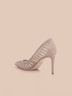 The Lenox Mesh Pump is a pointed-toe, high-heeled suede shoe in light beige with sheer striped mesh sides, shown against a plain light peach background.