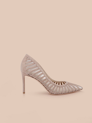 The Lenox Mesh Pump is a single nude suede shoe with a pointed toe and cutout mesh design, featuring an elegant heel, displayed on a plain light peach background.