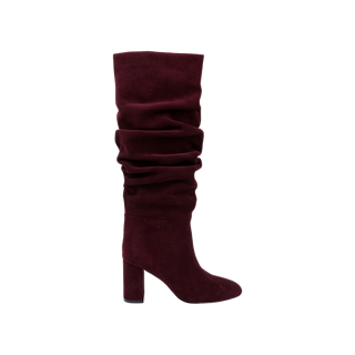The Fletcher Boot is a single knee-high, slouchy suede boot in rich burgundy, featuring a chunky block heel and a relaxed shaft for an effortlessly bohemian chic style, showcased on a plain white background.
