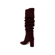 The Fletcher Boot—a knee-high, slouchy suede boot in rich burgundy, featuring a chunky block heel—is displayed on a plain white background, making it the perfect piece to add bohemian chic style to your look.