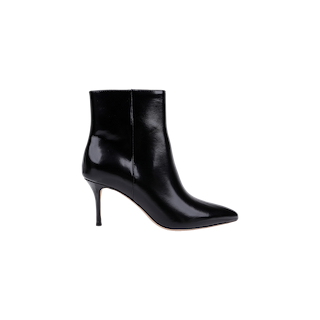 The Houston Bootie is shown in profile on a plain white background, featuring a high heel, pointed toe, and smooth black leather with a shiny finish. This sleek ankle bootie embodies timeless style and modern elegance.