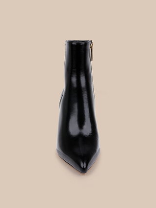 The Houston Bootie, a black leather ankle boot with a pointed toe and side zipper, is displayed upright and facing forward against a beige background.