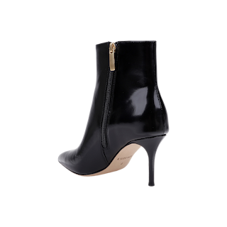 The Houston Bootie is a black leather ankle bootie featuring a pointed toe, a side zipper with a gold pull, and a sleek stiletto heel, shown against a plain white background.