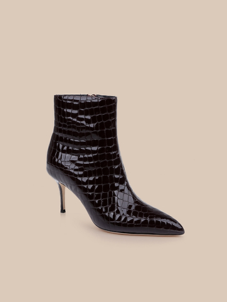 Black, crocodile-textured heeled bootie with a pointed toe and a thin high heel, crafted from sleek patent leather and displayed against a plain beige background.
