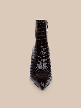 The Houston Bootie is a single black, glossy patent leather ankle bootie featuring a crocodile-pattern finish, pointed toe, and side zipper, displayed upright on a plain beige background.