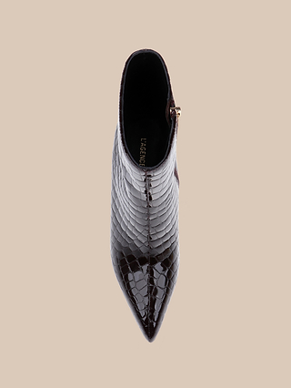 Top view of the Houston Bootie, a pointed-toe ankle bootie crafted from glossy, dark brown crocodile-embossed patent leather with a side zipper, set against a beige background.