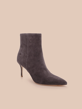 The Houston Bootie, a single dark gray suede bootie featuring a pointed toe and a slender high heel, is displayed against a light beige background.
