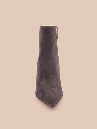 The Houston Bootie is displayed upright, viewed from the front against a plain beige background, highlighting the sleek silhouette of this stylish gray suede ankle boot.