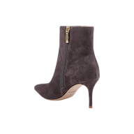 The Houston Bootie is a dark gray suede ankle boot featuring a pointed toe, side zipper, and a high stiletto heel. It has a light brown sole and is shown on a plain white background.
