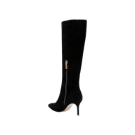 The Herald Boot is a black suede, knee-high boot featuring a pointed toe, stiletto heel, and a gold side zipper. Displayed against a plain white background, this boot highlights its sleek and elegant design.