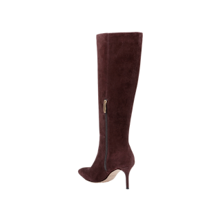 The Herald Boot is a single mahogany brown suede knee-high boot featuring a pointed toe, stiletto heel, and a convenient side zipper, shown on a white background.