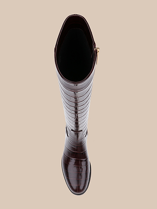 A top-down view of the Cortland Boot, a single knee-high boot crafted from dark brown, croc-embossed leather with a gold zipper, displayed on a plain beige background.