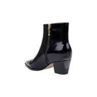 The Vesey Bootie, crafted in black leather with a shiny finish, features a pointed toe, side zipper, and a mid-height block heel, shown against a white background.