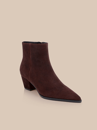 The Vesey Bootie, featuring a pointed toe and a mid-height block heel in mahogany suede, is displayed on a light beige background.