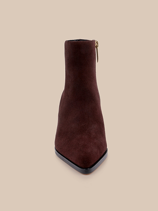 Front view of the Vesey Bootie, a mahogany suede ankle boot featuring a pointed toe and a gold side zipper, displayed against a plain beige background.