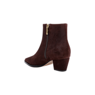 The Vesey Bootie, crafted from mahogany suede with a mid-height block heel, features a gold-pull side zipper and a slightly pointed toe. It is shown against a white background.