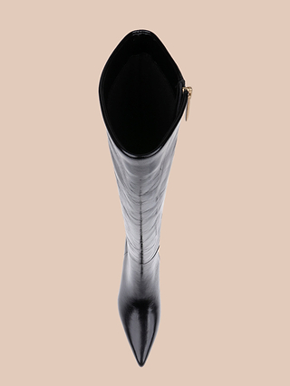 Top view of the Baxter Boot—a single comfortable, stylish knee-high boot featuring a pointed toe and a side zipper, crafted from sleek patent leather and displayed against a beige background.