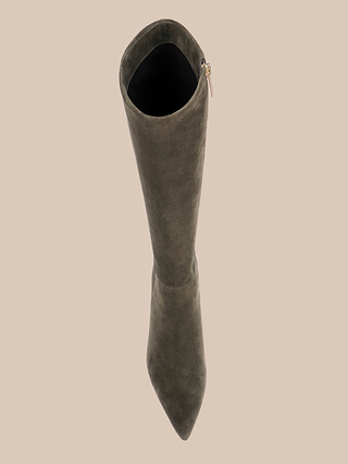 The Baxter Boot, a knee-high style in ash olive green suede, is shown from above featuring a pointed toe and a side zipper with a gold pull tab, set against a plain beige background.