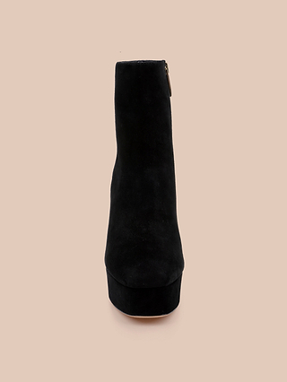 The Soho Bootie, a black suede platform block heel bootie, is shown from the front against a beige background.
