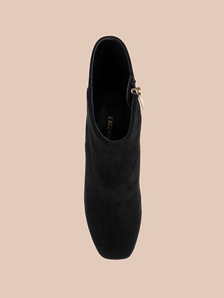 Top view of the Soho Bootie—a single black suede bootie featuring a gold side zipper and a platform block heel—displayed against a neutral beige background.