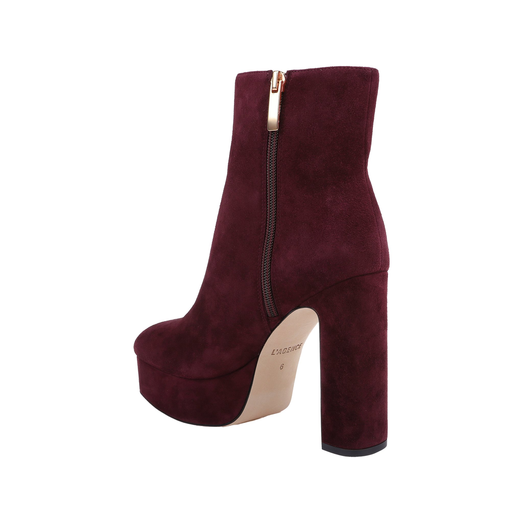 The Soho Bootie, shown on a white background, features burgundy suede, a platform sole, chunky block heel, gold zipper detail, and a light-colored sole.