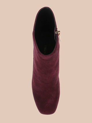 A top view of the Soho Bootie in burgundy suede, featuring a rounded toe, block heel, and a gold side zipper, set against a beige background.