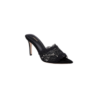 The Penn Mule is a black lace sandal with a pointed toe and an intricate lace overlay on the front strap, set against a plain white background. Its sophisticated design is finished with a sleek stiletto heel.
