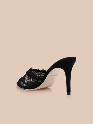 The Penn Mule, a black lace high-heeled stiletto with a peep toe, is displayed against a light beige background.