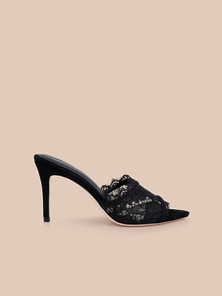 The Penn Mule is a black lace high-heeled stiletto with an elegant open, pointed toe, showcased against a plain beige background.