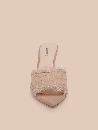The Penn Mule, a single nude-colored lace mule featuring elegant open-toe styling and delicate lace detailing, is displayed against a matching nude background and boasts a comfortable memory foam insole for all-day wear.