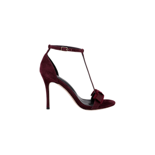 Introducing the Lerner Sandal: a high-heeled stiletto featuring a burgundy suede upper with an ankle strap, T-bar design, and open toe, complete with a decorative bow on the front. This elegant sandal offers both sophistication and style for any occasion.