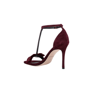 The Lerner Sandal features a burgundy suede upper with a stiletto heel, T-strap design, ankle buckle, and open toe, displayed against a plain white background.