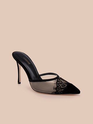 The Semois Mule is a black suede heel mule with a pointed toe, mesh sides, and elegant lace detailing, featuring a striking stiletto heel and beautifully presented on a beige background.