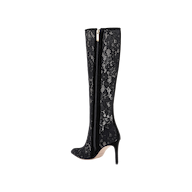 The Chambers Boot is a black knee-high stiletto heel boot with a pointed toe, elegantly covered in black lace, featuring a side zipper closure and a light-colored sole, displayed on a plain white background.