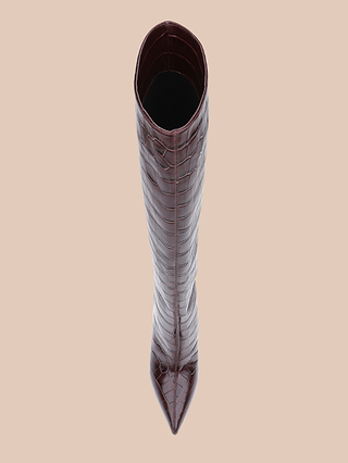 A single Lafayette Boot in brown crocodile-embossed leather, featuring a high stiletto heel, is viewed from above on a light beige background.