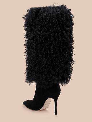 Introducing the Sheridan Boot: a high-heeled black boot featuring a pointed toe and a tall, textured, curly faux fur shaft that extends from the ankle to just below the knee. Set against a plain beige background, this striking piece captures the luxurious essence of black faux fur boots.
