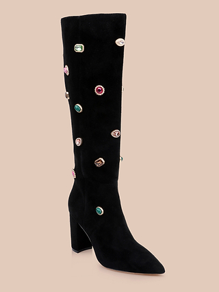 Introducing the Concourse Boot: a black, knee-high luxury statement boot featuring a block heel and pointed toe, adorned with vibrant jewel-like embellishments scattered across the surface.
