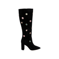 The Concourse Boot is a black, knee-high style featuring a block heel and pointed toe, embellished with multiple colorful crystal accents scattered across the shaft and foot—an eye-catching statement boot designed for luxury impact.