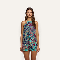 A woman wears a Kochi Cover-Up Top, a sleeveless, halter-neck resort wear piece featuring a colorful blue, teal, and magenta paisley print with a layered, draped front and chain details.
