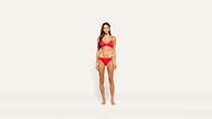 A woman stands barefoot against a plain white background, wearing a matching red bikini set.