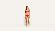 Woman with long brown hair stands barefoot against a plain white background, wearing a red two-piece bikini set. She is facing forward with a neutral expression and relaxed posture.