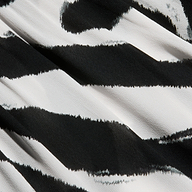 Close-up of the Ambala Cover-Up Top, featuring a black and white zebra print. The fabric is slightly textured and softly drapes with gentle folds.