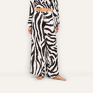 A woman models the Geraldine Cover-Up Pant featuring a zebra print, paired with a matching cropped top. She stands barefoot against a plain background, with her head cropped out of the frame.
