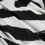Close-up of the Geraldine Cover-Up Pant in a black and white zebra print with a striking stripe pattern. The textured fabric highlights wavy, irregular lines as light and shadow play across the surface.