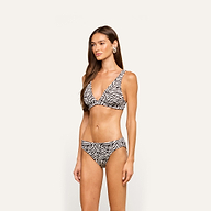 A woman models the Nicole Bikini Bottom in a zebra print with moderate coverage, standing against a plain light background and looking slightly to her left with a neutral expression.