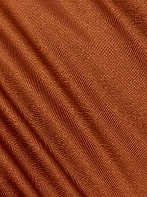 Close-up of the Nicole Bikini Bottom in brown fabric, featuring soft diagonal folds and a subtle sheen. Its smooth, slightly metallic texture offers moderate coverage and stylish UPF 50 sun protection.