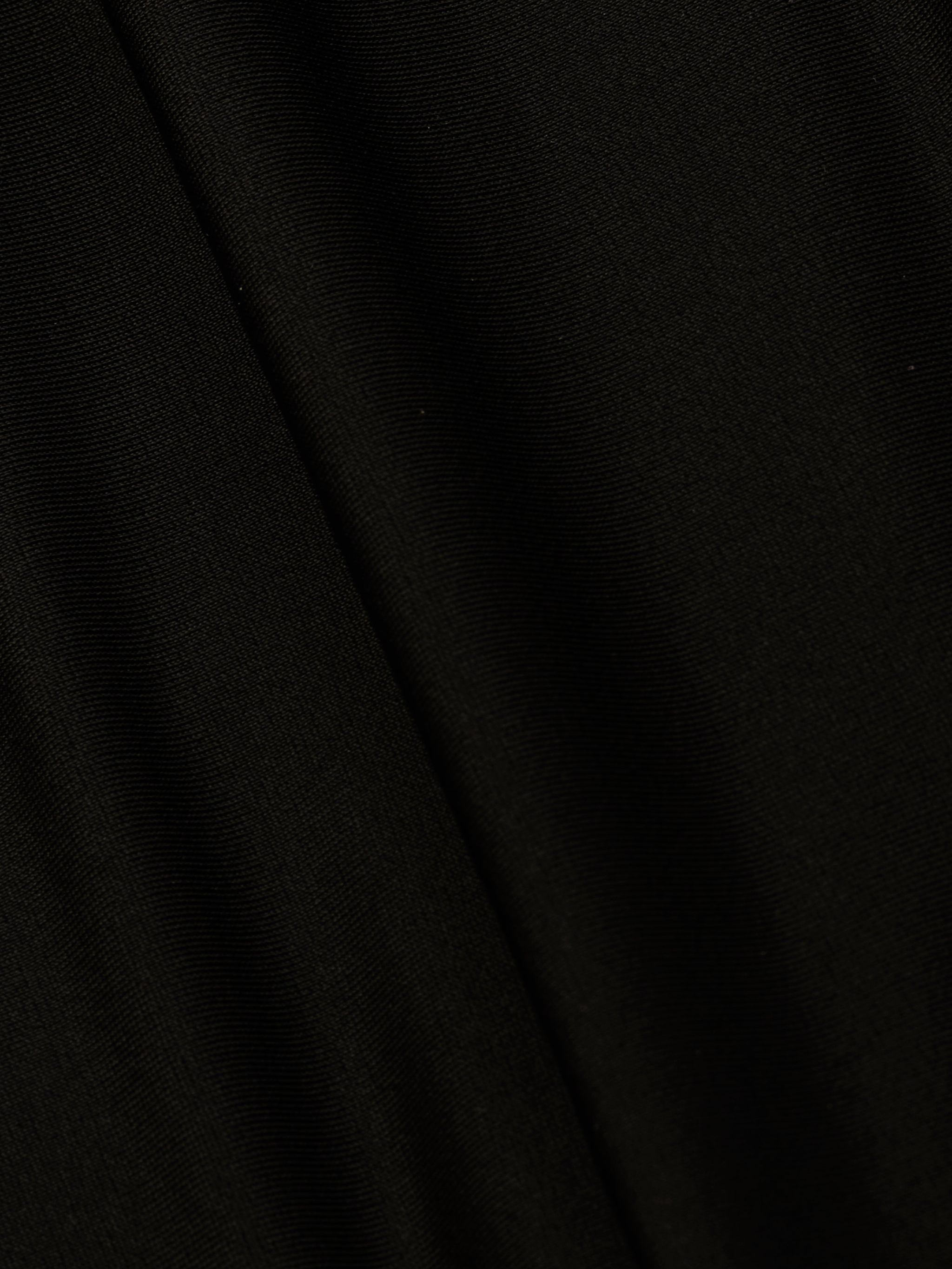 A close-up of the Emelia Bandeau One-Piece Swimsuit in black, highlighting its smooth texture, fine weave pattern, and four-way stretch nylon with a subtle diagonal fold in the fabric.