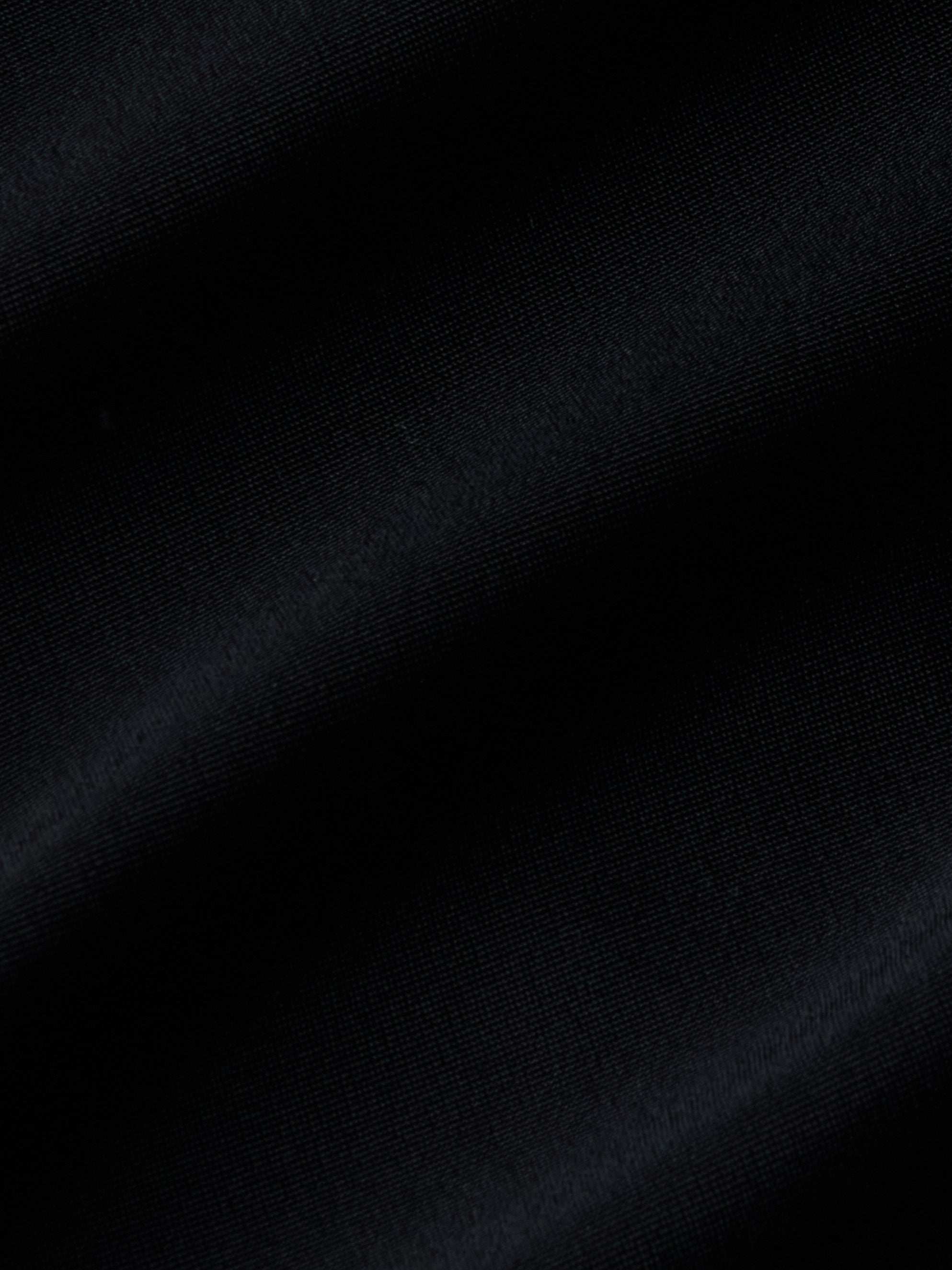 Close-up of black fabric with visible diagonal ribbing and gentle folds, highlighting the texture and subtle sheen—ideal for the Gianna Brazilian Bikini Bottom with its mid-rise fit and cheeky cut.